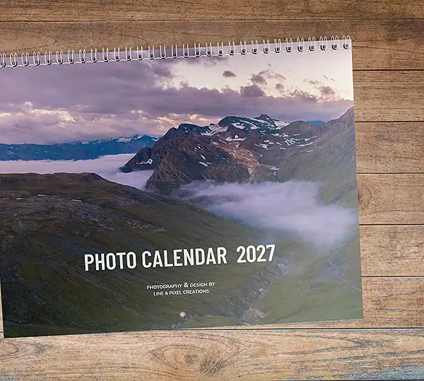 Front cover of the A Year of Scenic Adventures 2027 photo wall calendar featuring a dramatic mountain landscape above the clouds.